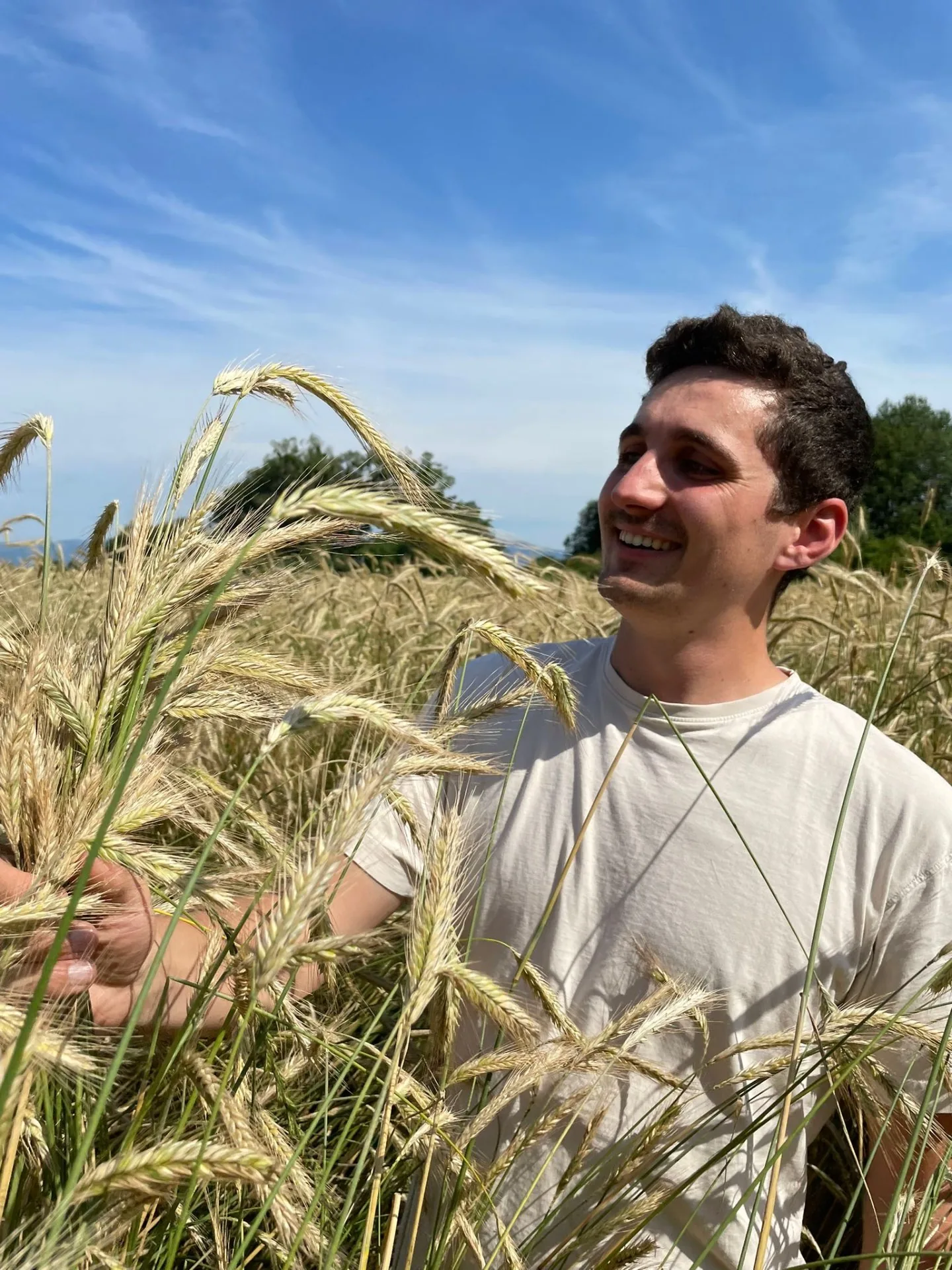 Portrait — Bäckermeister im Kornfeld mit frischem Brot
